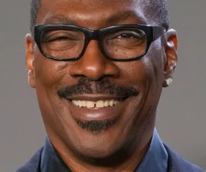 Comedian Eddie Murphy smiling in front of a gray background.
