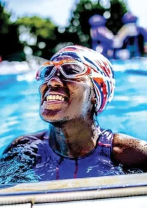 Special Olympics gold medal athlete and Motivational Speaker African American Ashton Smith smiling in a pool