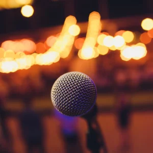 Close up of a microphone with blurred lights in the background.