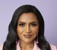 Mindy Kaling comedian and writer in a pink blouse in front of a purple background.