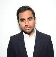 Stand- up Indian comedian Aziz Ansari in a black coat and white shirt.
